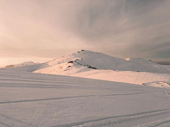 Scenic view of snowcapped mountain against sky during sunset