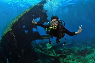 A woman doing scuba diving near a shipwreck
