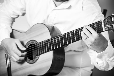 Midsection of man playing guitar