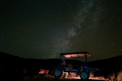 Cars on field against sky at night