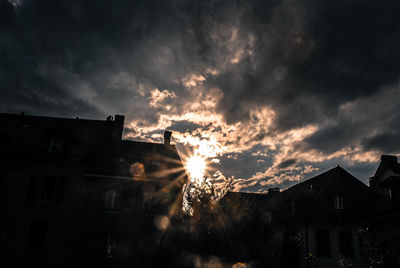 Low angle view of silhouette houses against sky at sunset