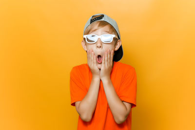 Portrait of boy wearing sunglasses against yellow background