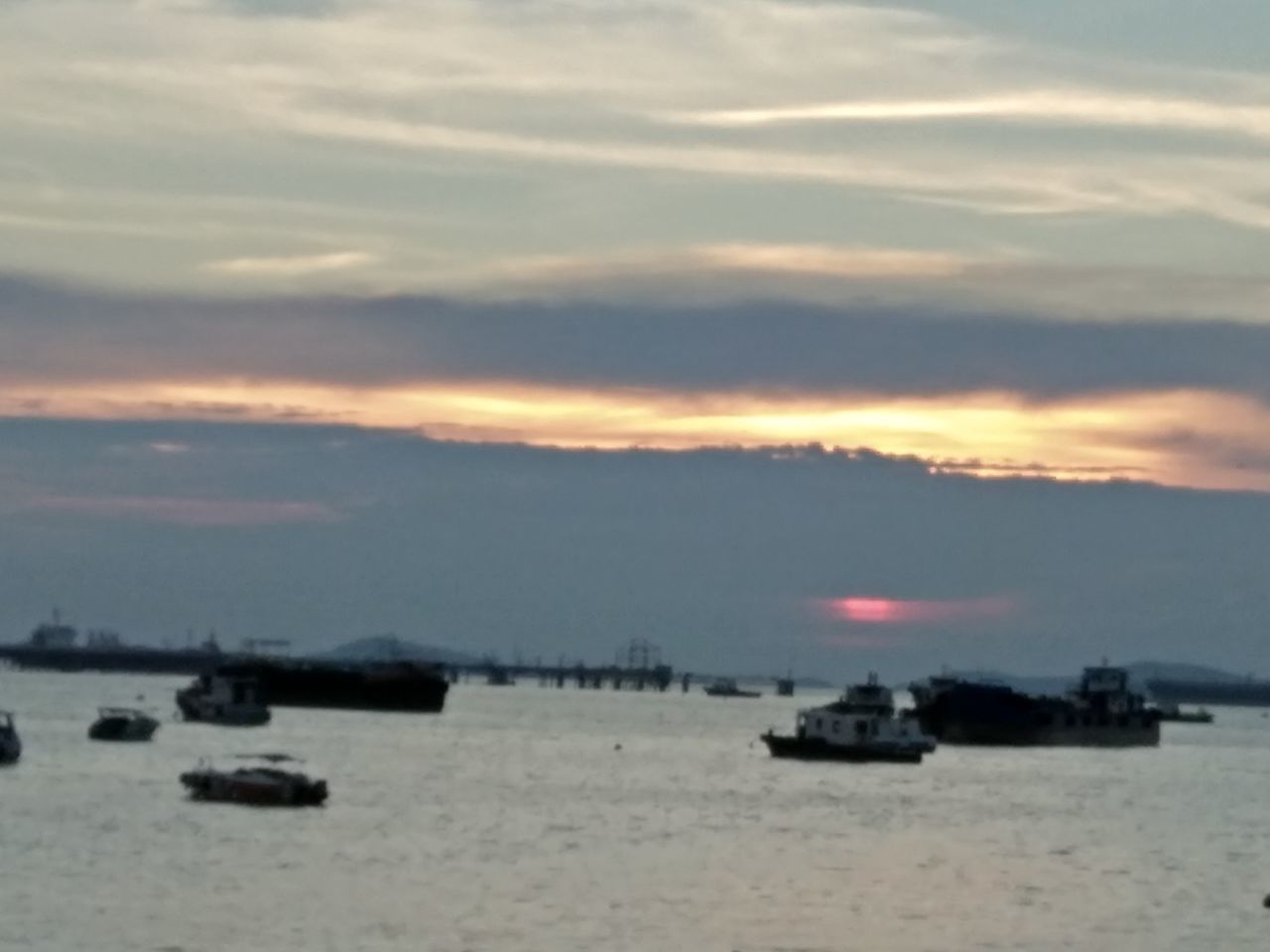 BOATS SAILING IN SEA AGAINST SUNSET SKY