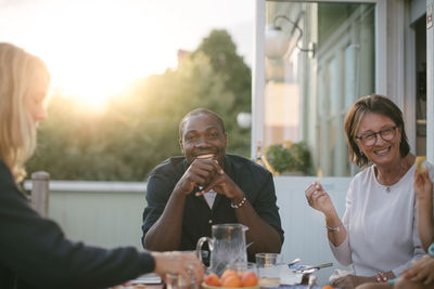 Smiling multi-generation family having lunch at table on porch