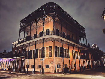 Low angle view of illuminated french quarter house against a night sky.