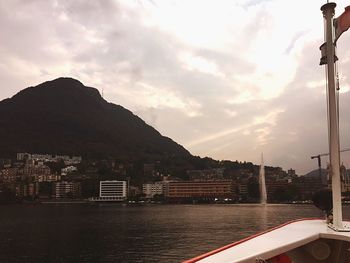 Scenic view of town by sea against sky