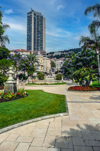 Park by buildings against sky in city