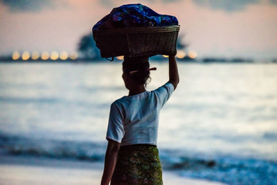 Rear view of man looking at sea against sky