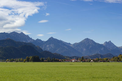 Scenic view of field and mountains against sky