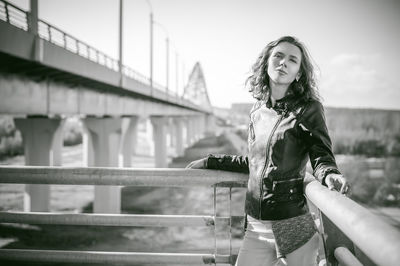 Portrait of young woman on bridge against sky