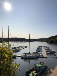 Sailboats moored in lake against clear sky