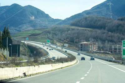Vehicles on road against mountains