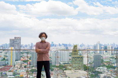 Full length of man standing against buildings in city