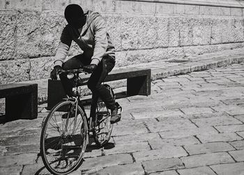 Man riding bicycle on cobblestone street