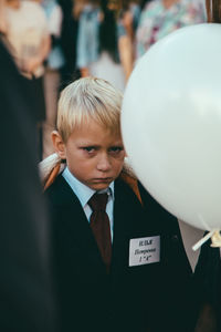 Portrait of boy with balloons standing outdoors