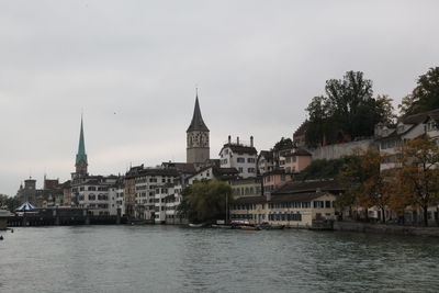 River amidst buildings in city against sky