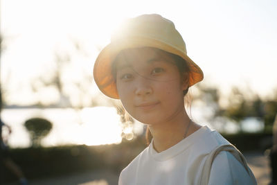 Portrait of teenage girl wearing hat standing outdoors