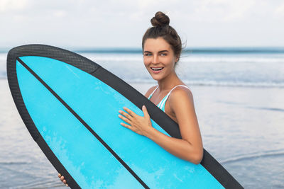 Portrait of young woman sitting at beach