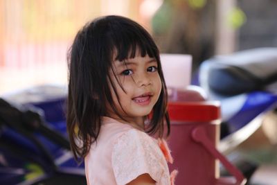 Side view portrait of girl smiling while standing outdoors