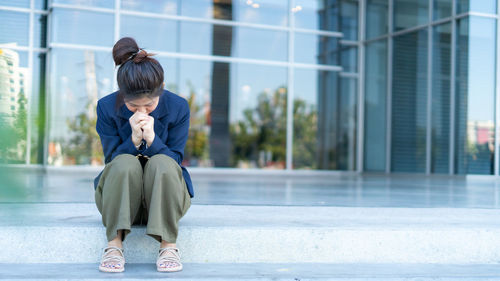 Full length of woman sitting outdoors