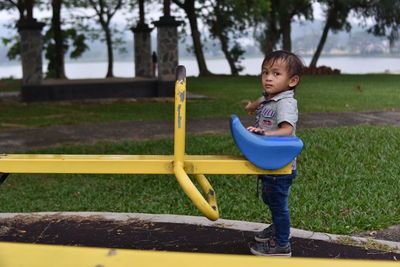 Full length of cute boy standing at playground