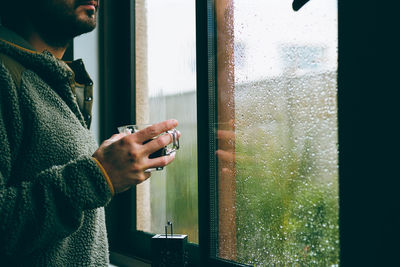 Man drinking coffee at window