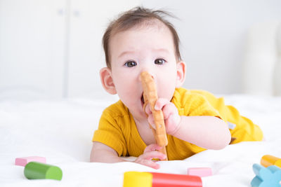 Portrait of cute baby boy lying on bed at home