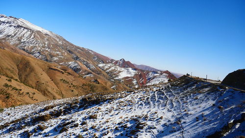 Scenic view of snowcapped mountains against clear blue sky