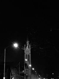 Low angle view of illuminated street light against buildings at night