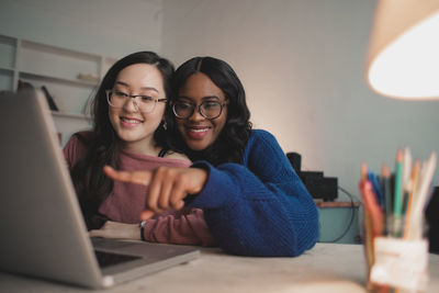 Portrait of a smiling young woman using laptop