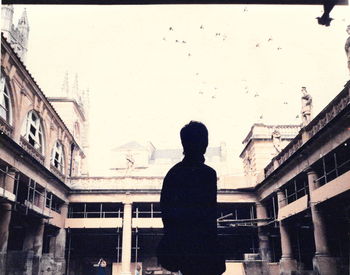 Rear view of man standing in front of building