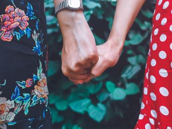 Midsection of couple hands against blurred background