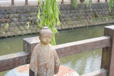 Close-up of child on lake against stone wall