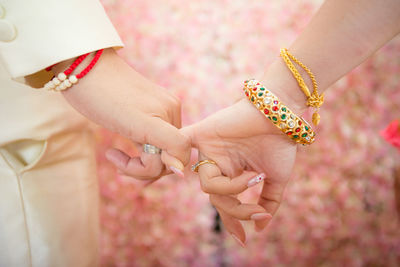 Cropped image of couple holding hands during wedding ceremony