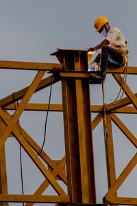 Man working at construction site against sky