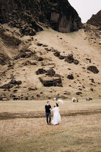 Rear view of couple standing on land