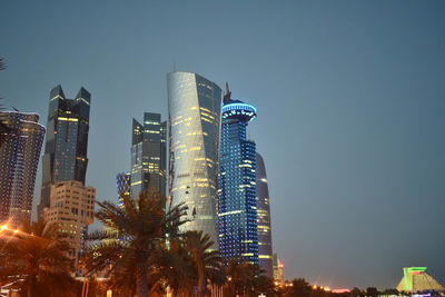 Low angle view of illuminated buildings against clear sky