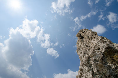 Low angle view of rock formation against sky on sunny day