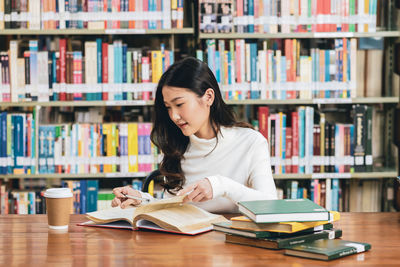 Young woman sitting on book