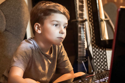 Little boy surfing the net on a computer at home.