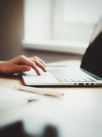 Close-up of person using laptop on table