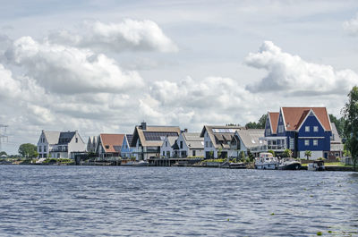 Lakeside houses under a sky with clouds