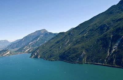 Scenic view of lake and mountains against clear blue sky