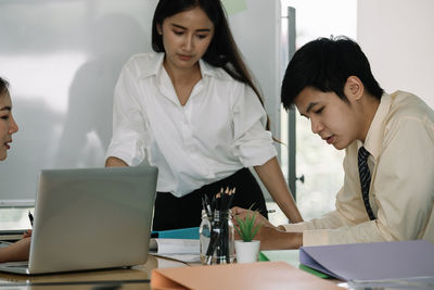 Female friends using laptop at table