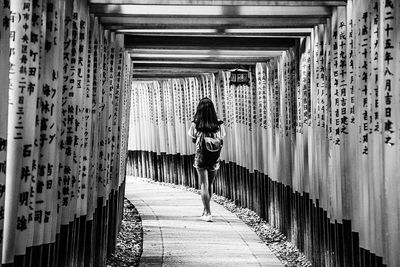 Rear view of woman walking at fushimi inari-taisha
