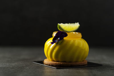 Close-up of yellow lemon on table against black background