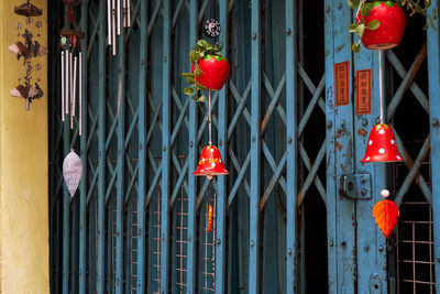 Red lanterns hanging on metal gate against building