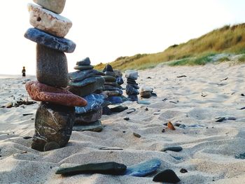 Stack of pebbles on beach against sky