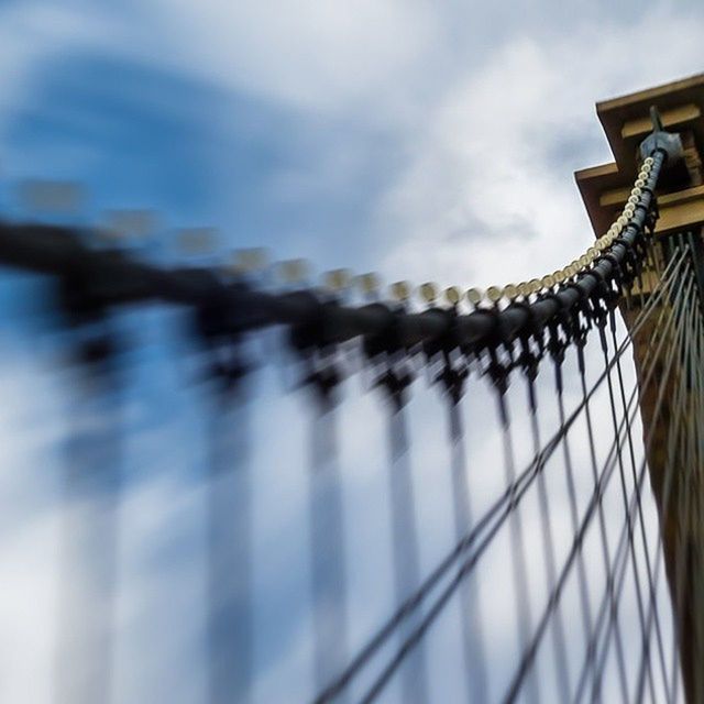 sky, focus on foreground, built structure, building exterior, architecture, metal, close-up, fence, low angle view, outdoors, day, railing, selective focus, no people, protection, cloud - sky, cloud, metallic, city, safety