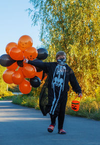 Rear view of woman with balloons in forest